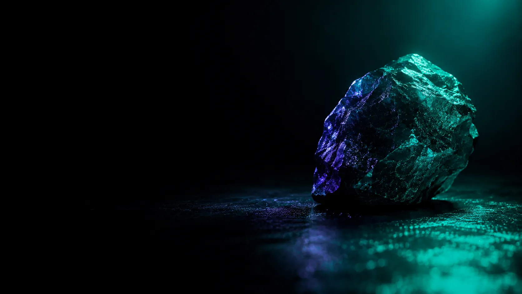 Una roca de canto vivo sobre una superficie oscura, iluminada por dos luces: turquesa por un lado, violeta por el otro.